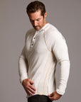 Man modeling a beige long-sleeve shirt against a gray background