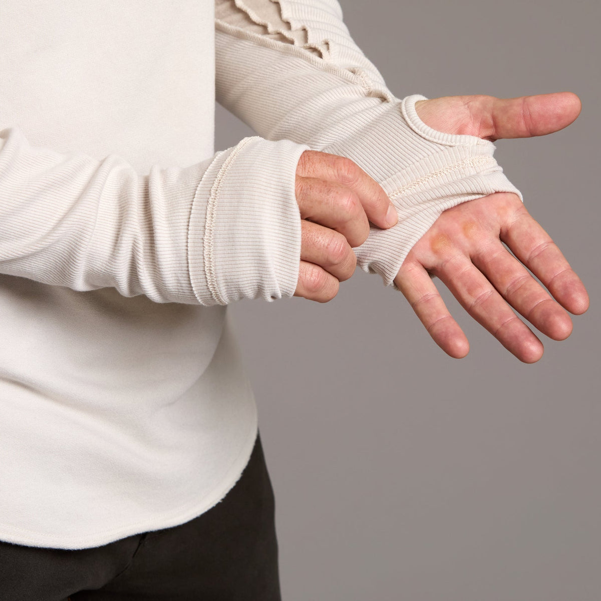 Man modeling a beige long-sleeve shirt against a gray background