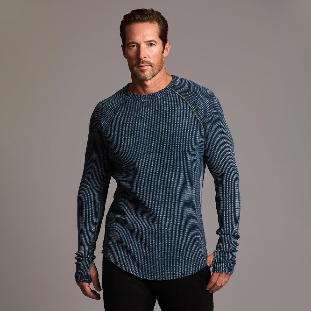 A man modeling a One Golden Thread Waffle Long Sleeve Raglan shirt in blue mineral