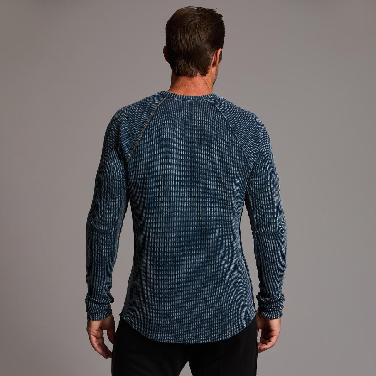 A man modeling a One Golden Thread Waffle Long Sleeve Raglan shirt in blue mineral