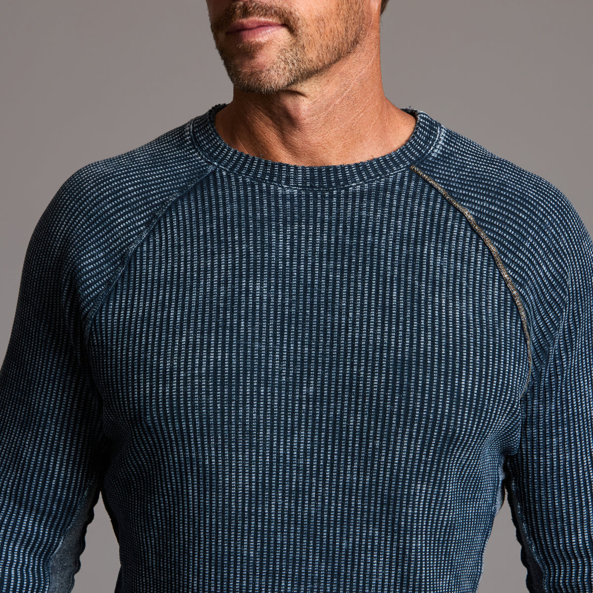 A man modeling a One Golden Thread Waffle Long Sleeve Raglan shirt in blue mineral