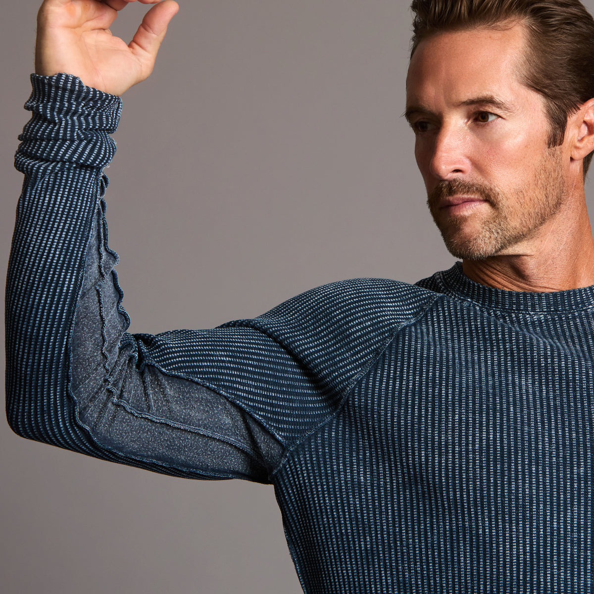 A man modeling a One Golden Thread Waffle Long Sleeve Raglan shirt in blue mineral