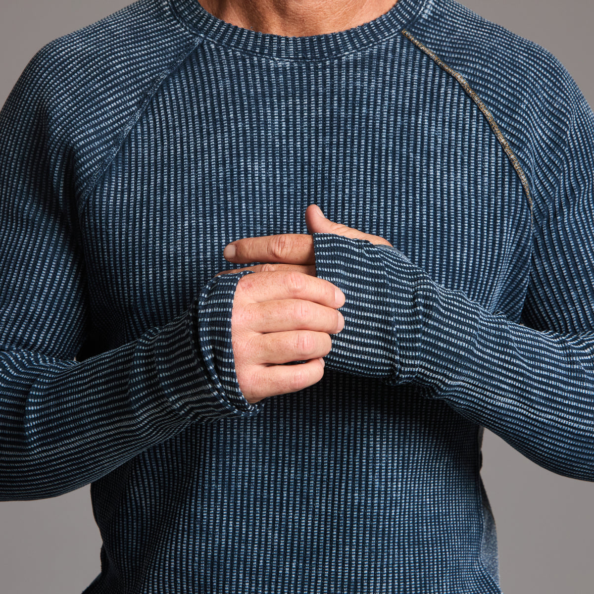 A man modeling a One Golden Thread Waffle Long Sleeve Raglan shirt in blue mineral