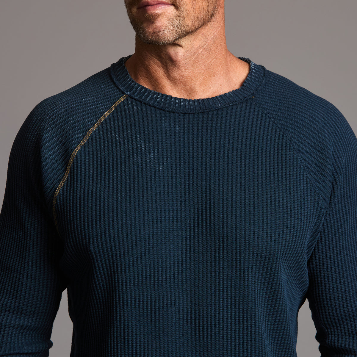A man modeling a One Golden Thread Waffle Long Sleeve Raglan shirt in blue mineral
