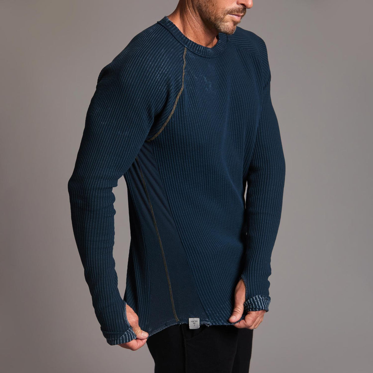 A man modeling a One Golden Thread Waffle Long Sleeve Raglan shirt in blue mineral
