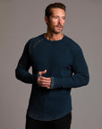 A man modeling a One Golden Thread Waffle Long Sleeve Raglan shirt in blue mineral