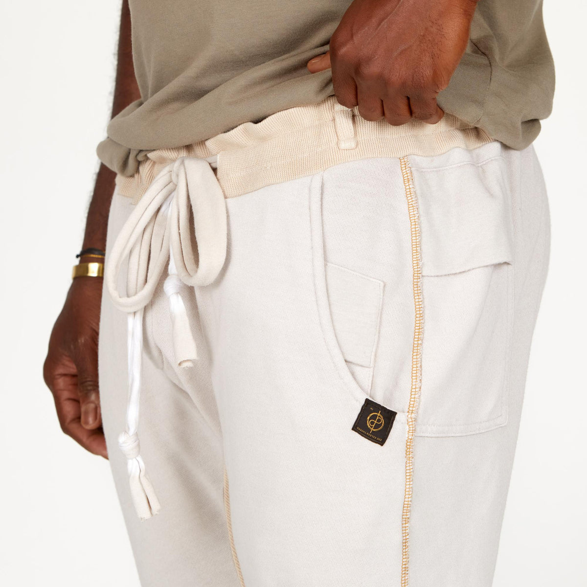 A man modeling white stone milanos mid shorts