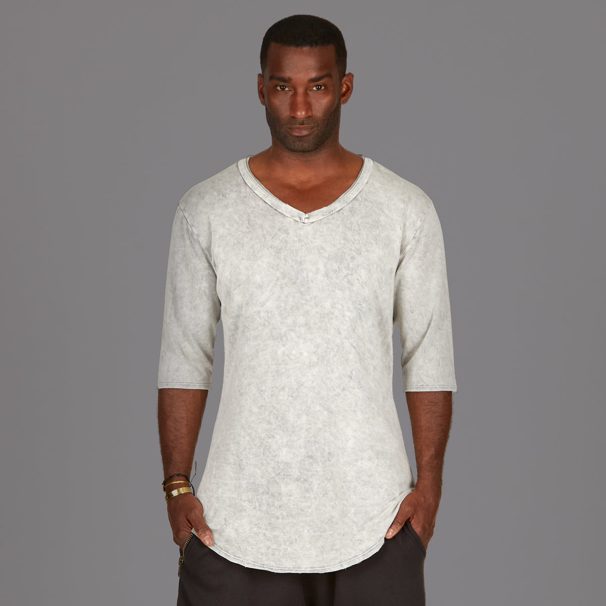 A man modeling in a grey mineral sweater v neck shirt