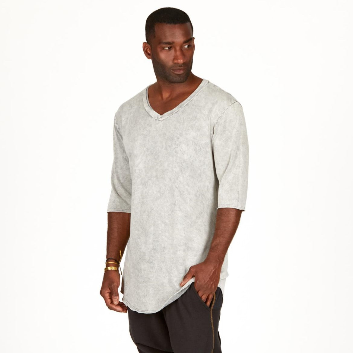 A man modeling in a grey mineral sweater v neck shirt