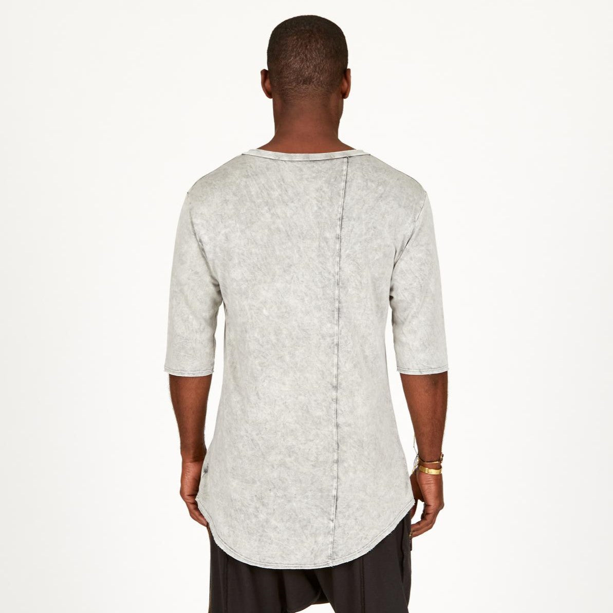 A man modeling in a grey mineral sweater v neck shirt