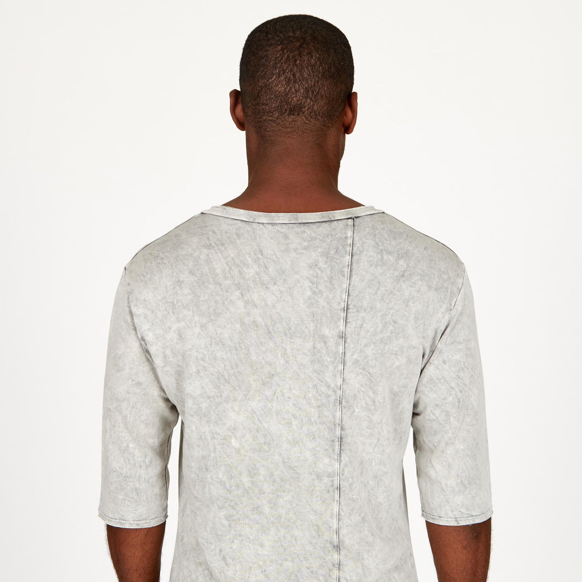 A man modeling in a grey mineral sweater v neck shirt