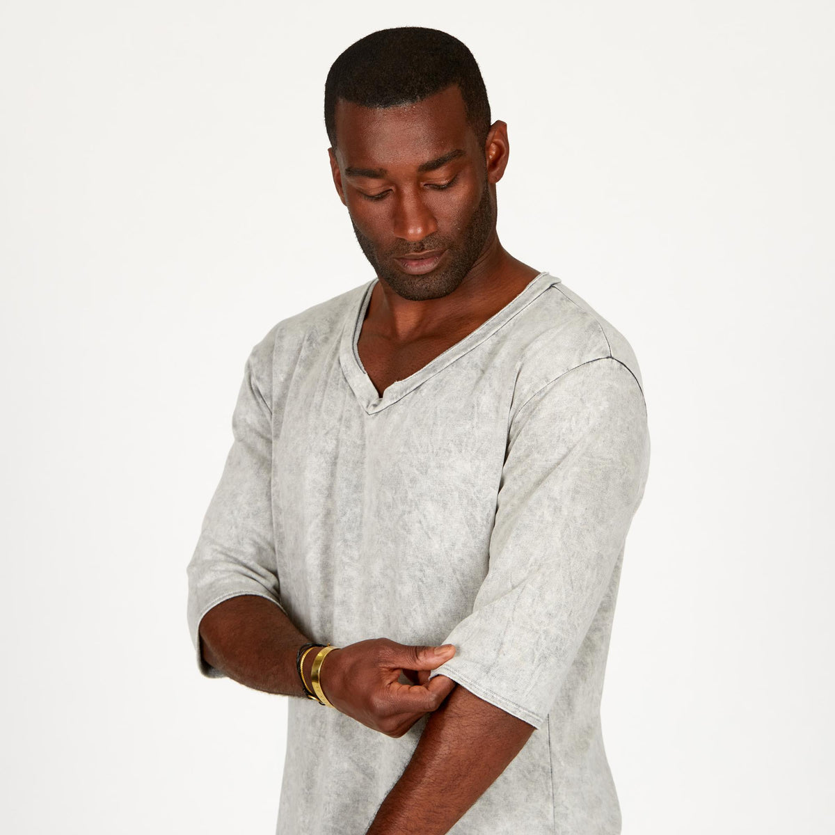 A man modeling in a grey mineral sweater v neck shirt