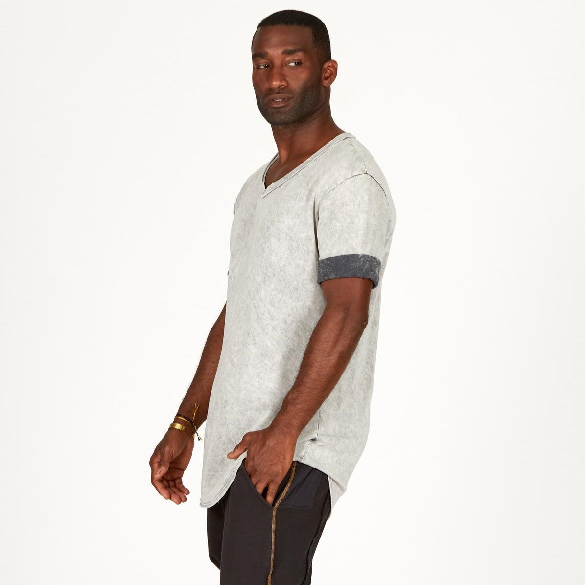 A man modeling in a grey mineral sweater v neck shirt