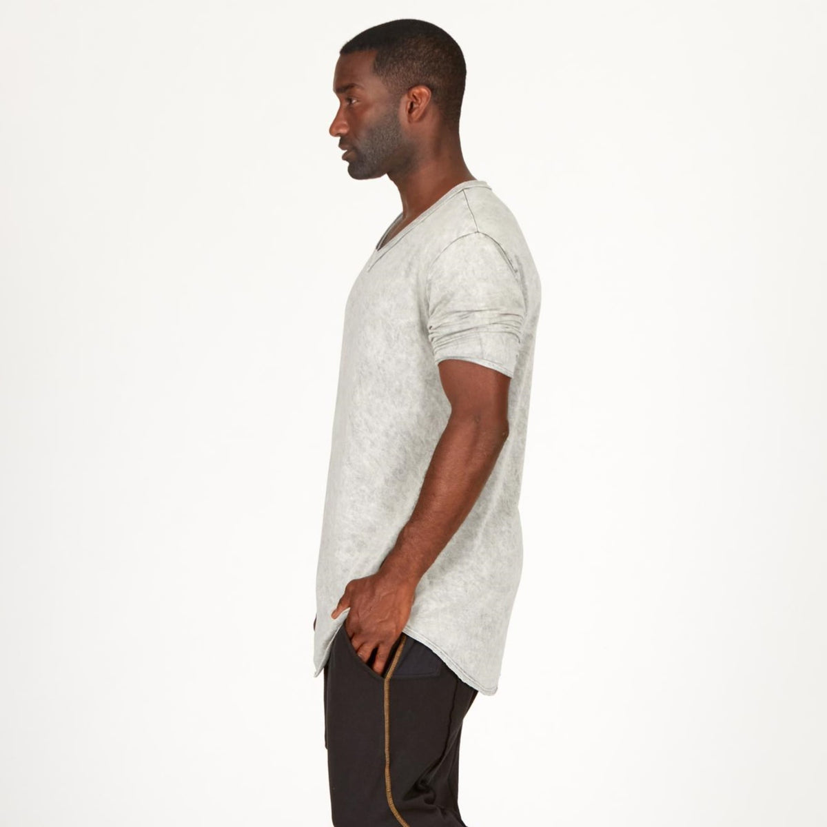 A man modeling in a grey mineral sweater v neck shirt