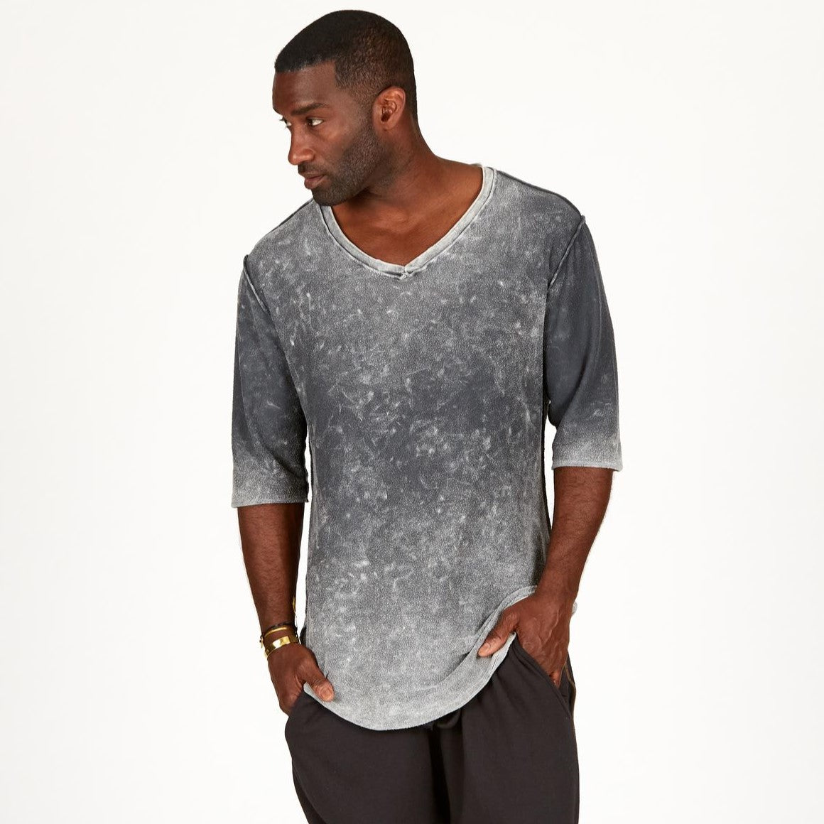 A man modeling in a grey mineral sweater v neck shirt