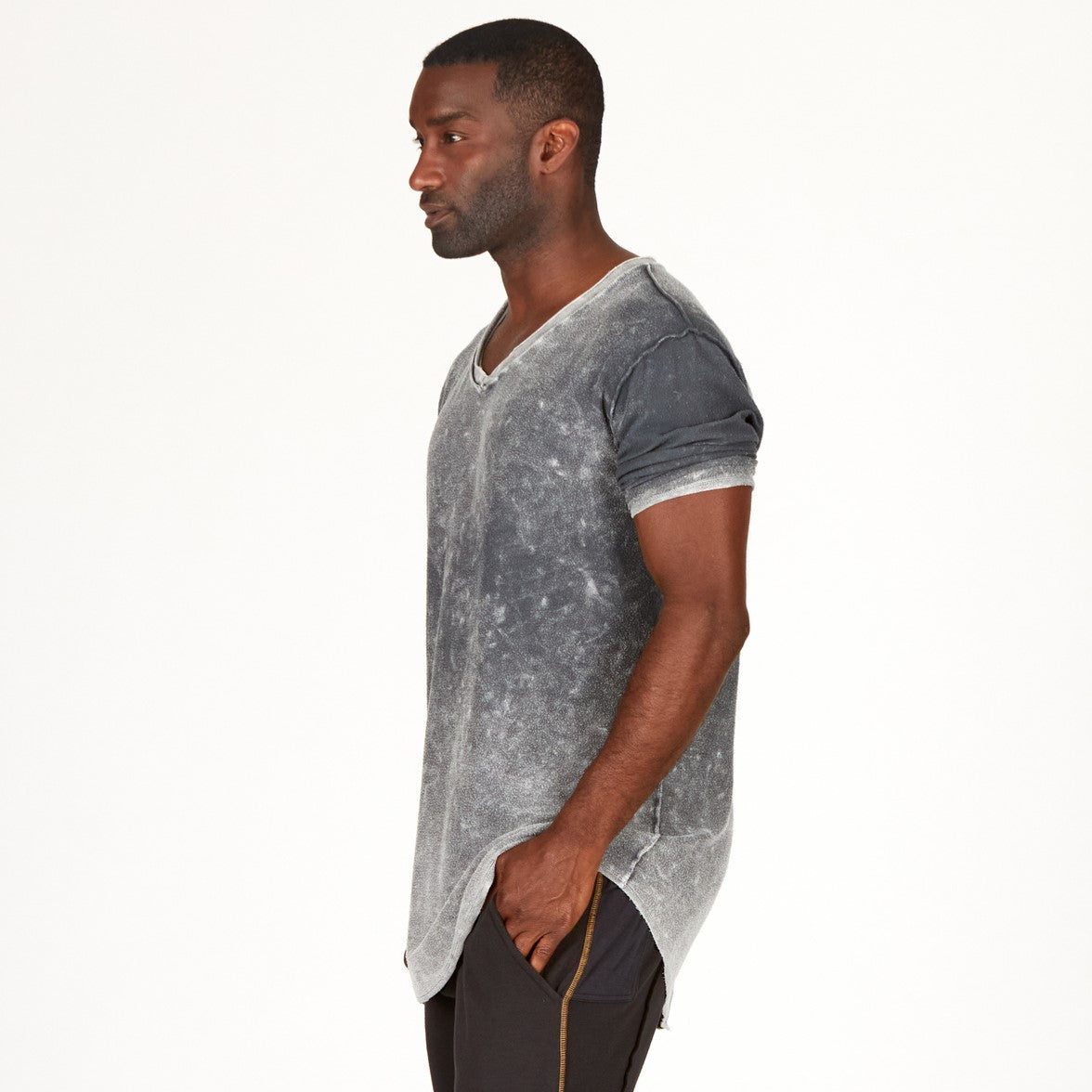 A man modeling in a grey mineral sweater v neck shirt
