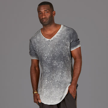 A man modeling in a grey mineral sweater v neck shirt