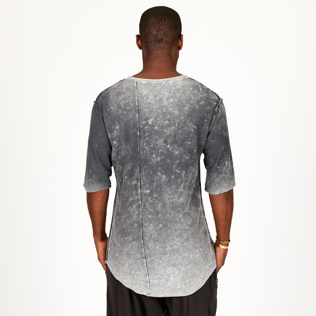 A man modeling in a grey mineral sweater v neck shirt