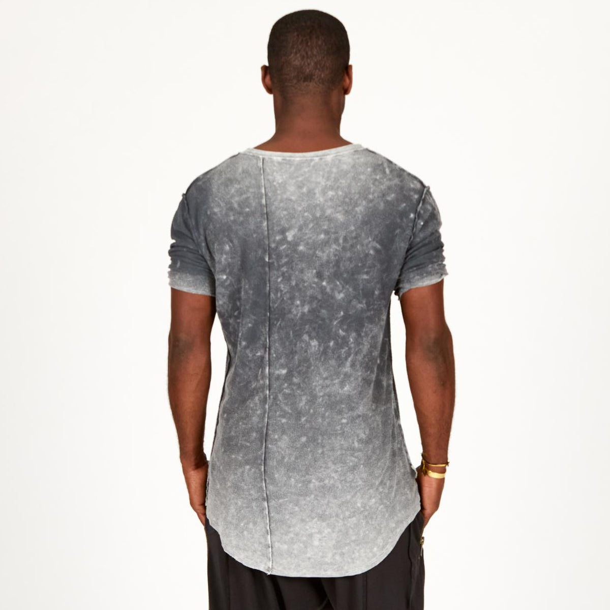 A man modeling in a grey mineral sweater v neck shirt