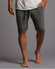 A man modeling urban forest green milanos mid shorts