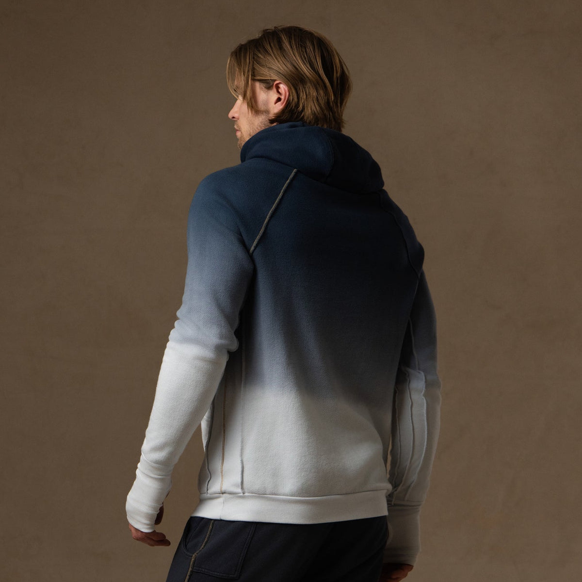 a male modeling the pullover plush hoodie in a blue gradient