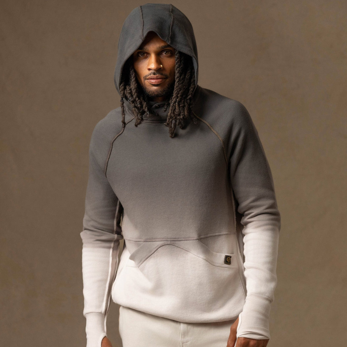 a male modeling the pullover plush hoodie in a grey gradient