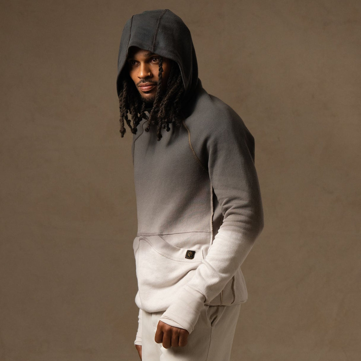 a male modeling the pullover plush hoodie in a grey gradient