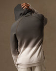a male modeling the pullover plush hoodie in a grey gradient