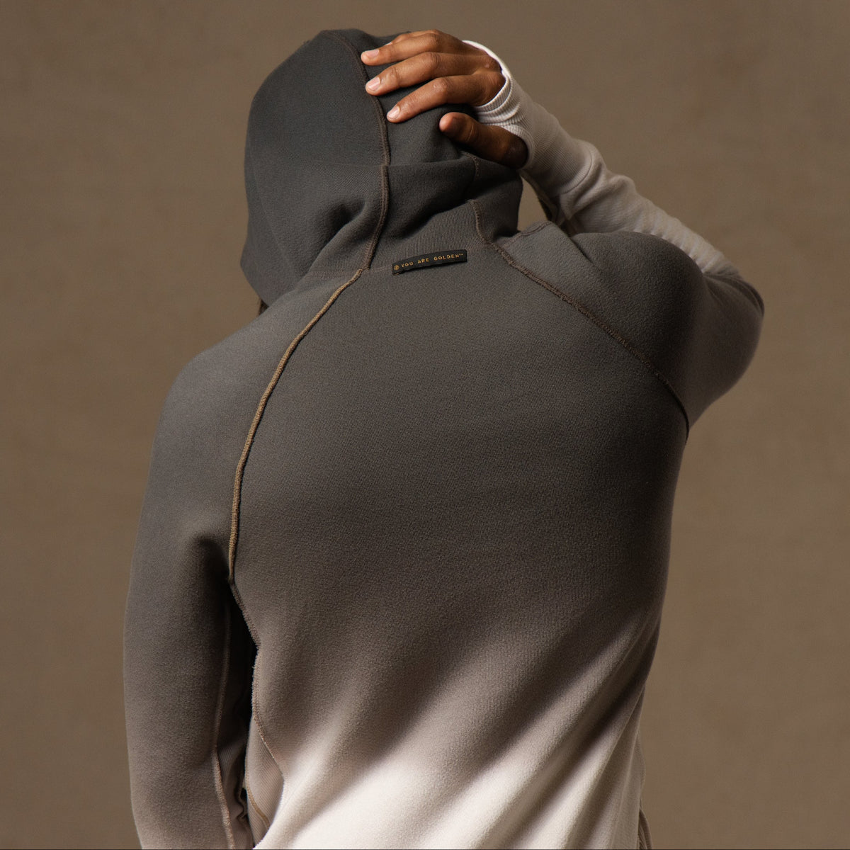 a male modeling the pullover plush hoodie in a grey gradient