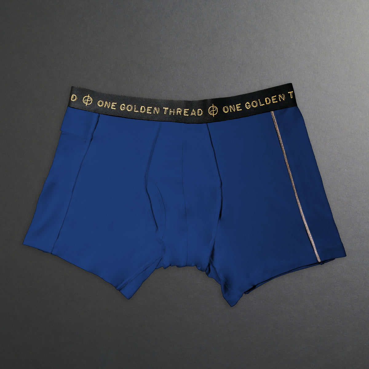 Blue boxer briefs with a black waistband featuring 'One Golden Thread' branding 