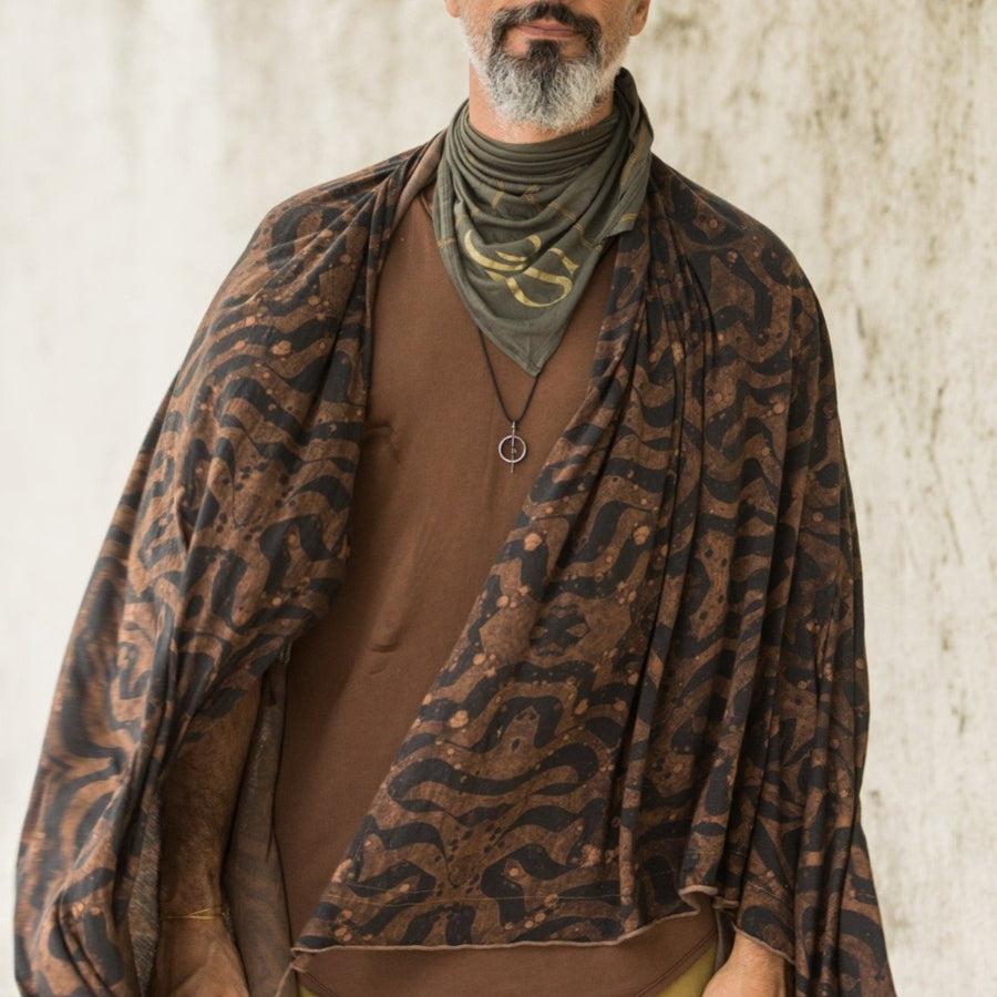 A man wearing the Artist Collab: Daniel Dugan x One Golden Thread Nature Wrap in Egyptian Tan color