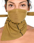 A woman wearing the One Golden Thread Versawrap as a face covering in the Golden Olive color