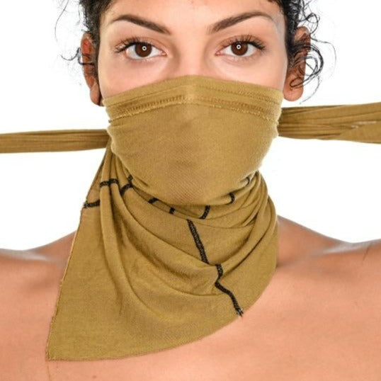 A woman wearing the One Golden Thread Versawrap as a face covering in the Golden Olive color