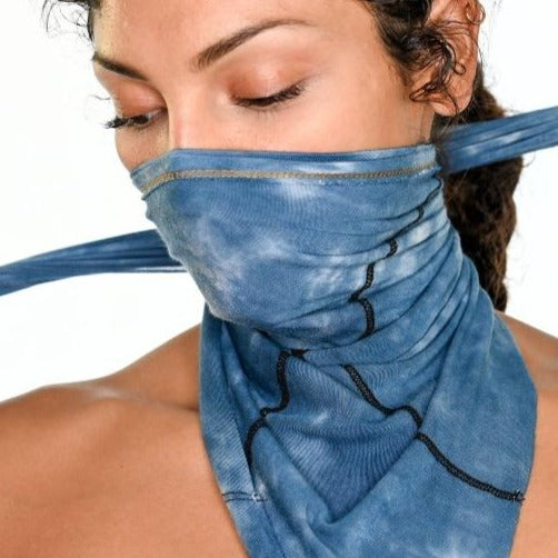 A woman wearing the One Golden Thread Versawrap as a face covering in Desert Blue TieDye color