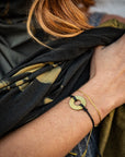A woman wearing a Customized MyIntent Gold Plated Black Twist Bracelet with the word "Grateful"