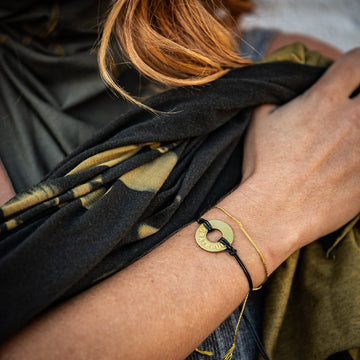 A woman wearing a Customized MyIntent Gold Plated Black Twist Bracelet with the word "Grateful"