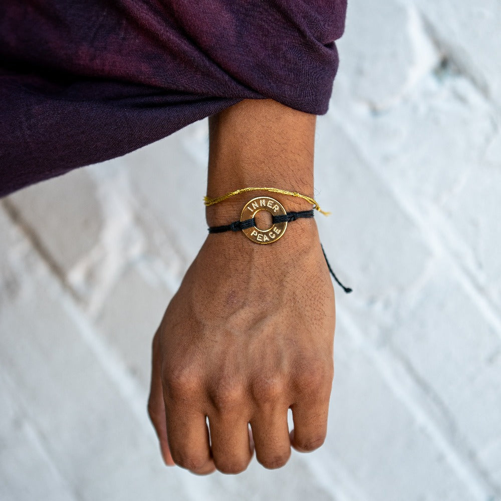 A person wearing a Customized MyIntent Gold Plated Black Twist Bracelet with the words "Inner Peace"