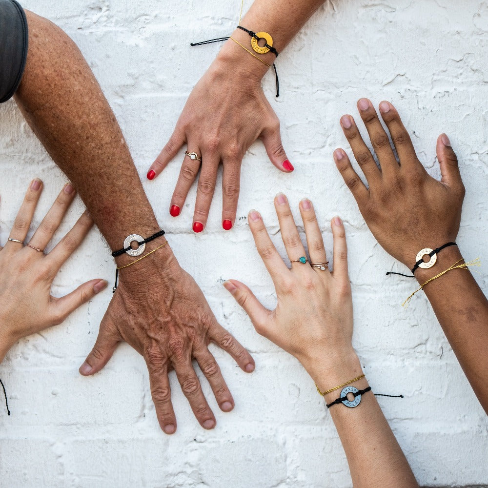 A group of people wearing their Customized MyIntent Black Bracelets with the words "Inner Power" "I Am Golden" "Grateful" and "Inner Peace"