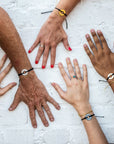 A group of people wearing their Customized MyIntent Black Bracelets with the words "Inner Power" "I Am Golden" "Grateful" and "Inner Peace"