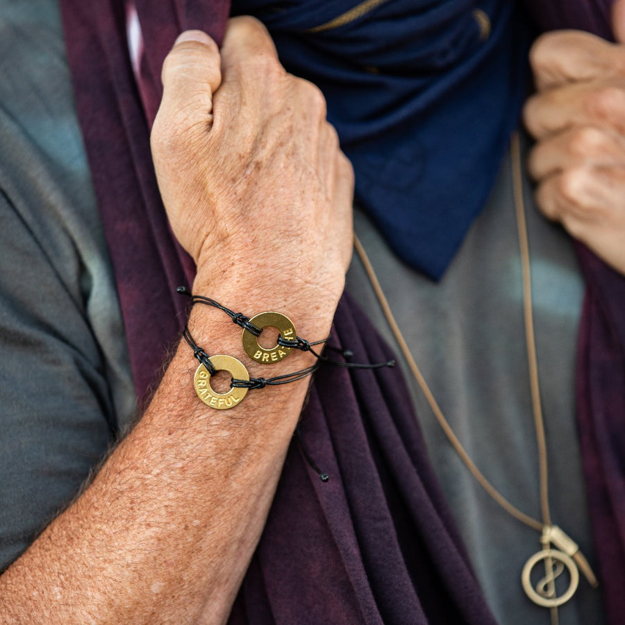 A man wearing customized MyIntent black bracelets with the words "Grateful" and "Breathe"
