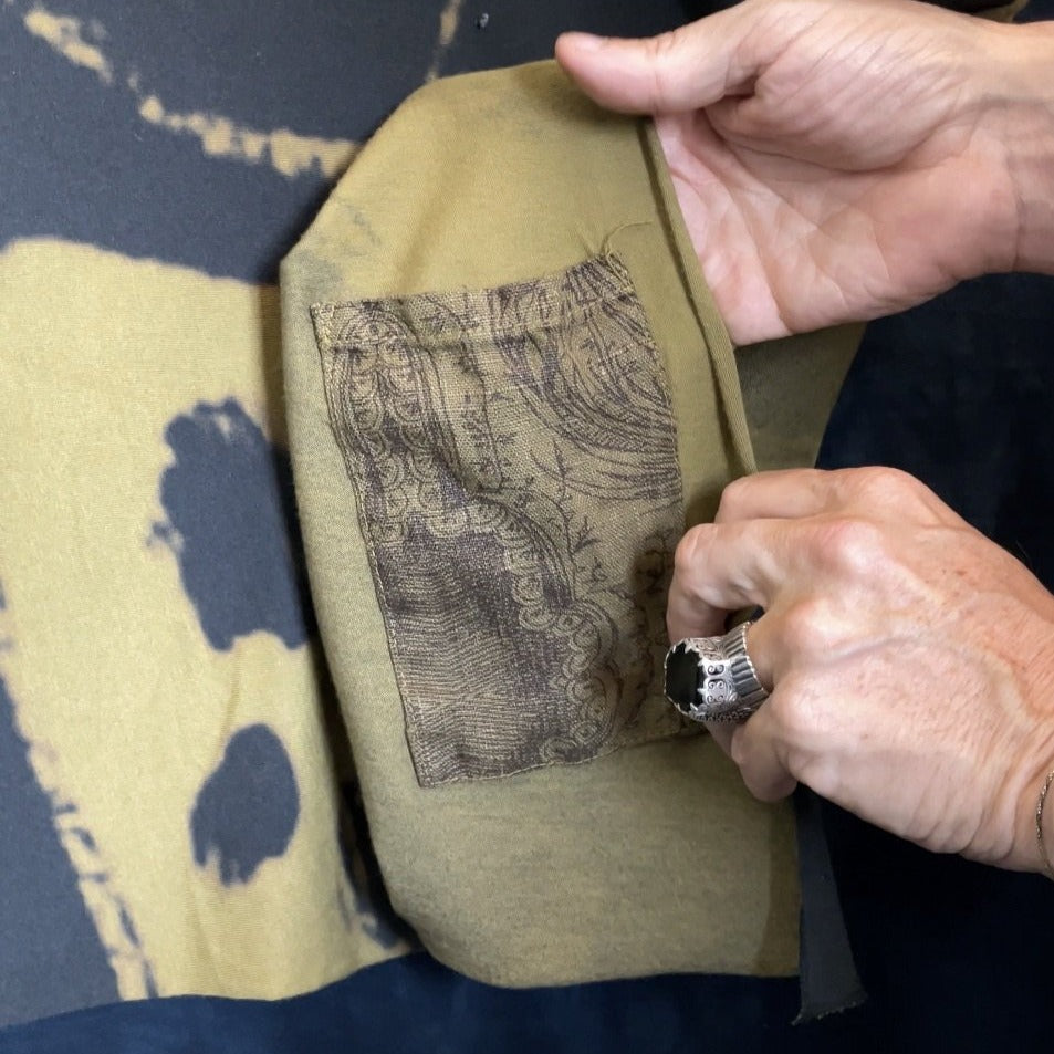 A man opening the pocket in the Minotaur Nature Wrap