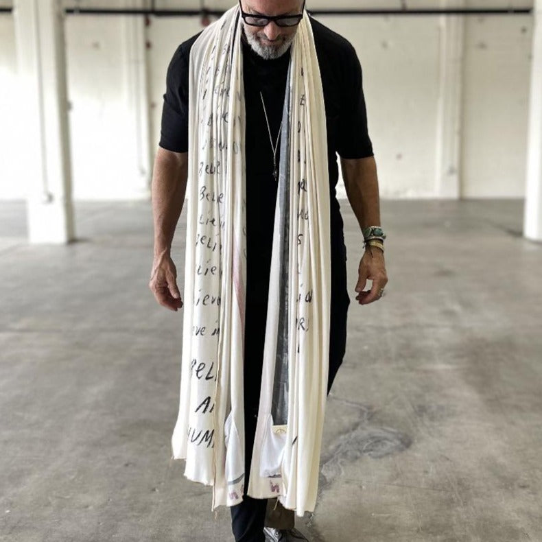 A man wearing the One Golden Thread Nature Scarf in the "I Believe" Poem