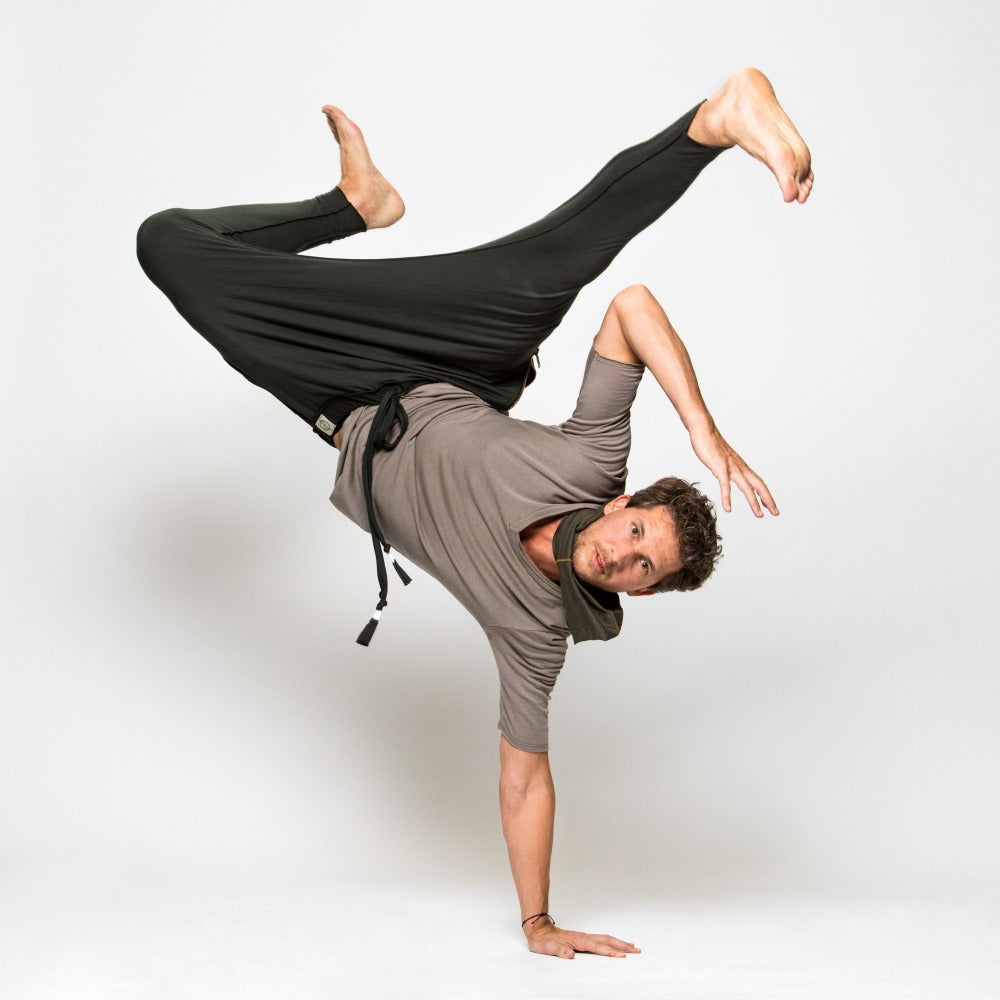 A man wearing the One Golden Thread Tree Pant in Urban Forest color