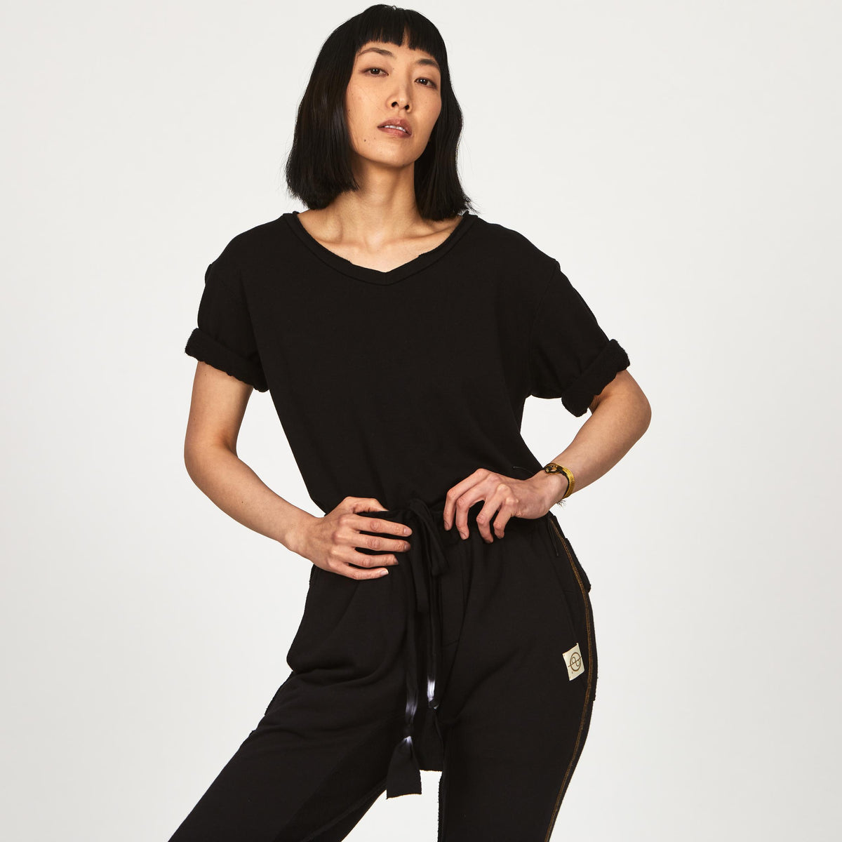 A woman wearing the One Golden Thread Fleece Sweater v neck shirt in the Black Onyx color