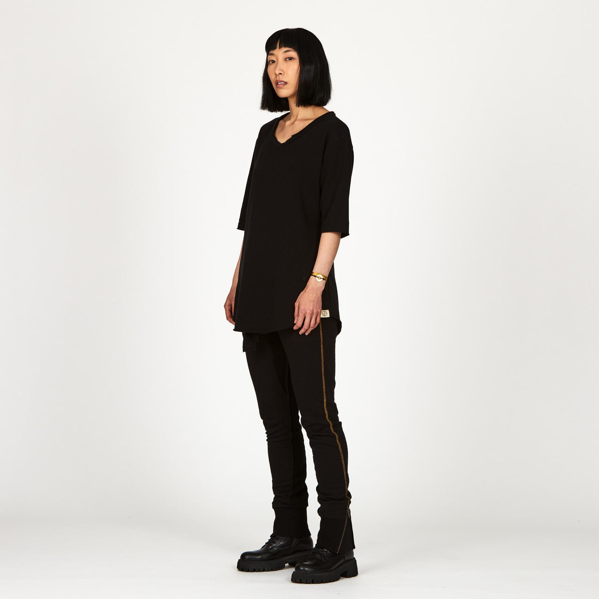 A woman wearing the One Golden Thread Fleece Sweater v neck shirt in the Black Onyx color
