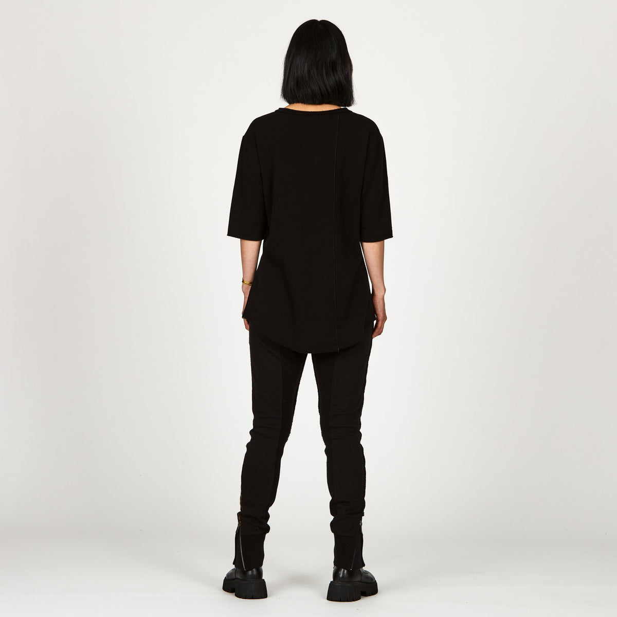 A woman wearing the One Golden Thread Fleece Sweater v neck shirt in the Black Onyx color