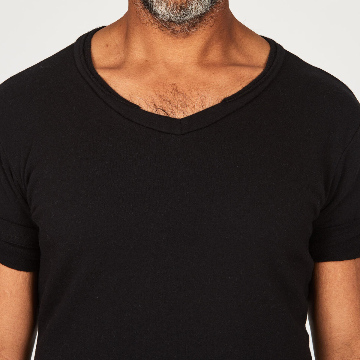 A man modeling in a black sweater v neck shirt