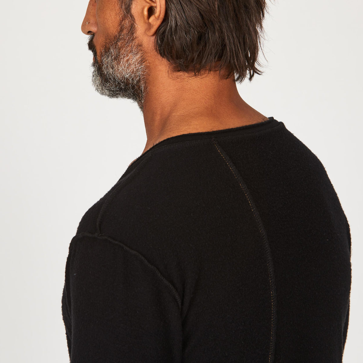 A man modeling in a black sweater v neck shirt
