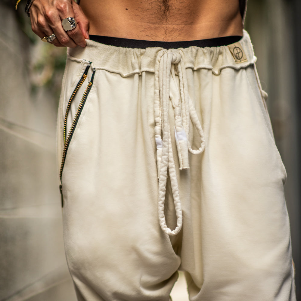 A man wearing the One Golden Thread Tree Pant in Ceremony Sand color