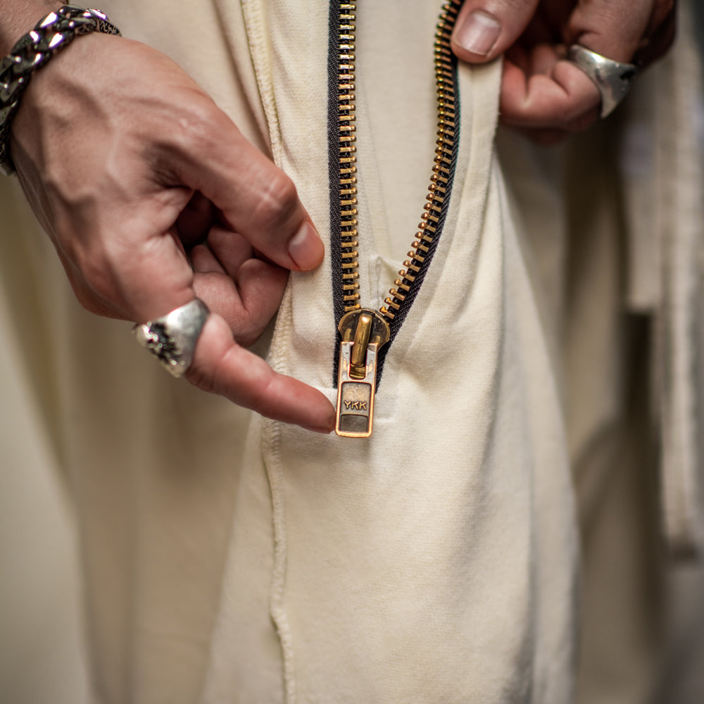 A man wearing the One Golden Thread Tree Pant in Ceremony Sand color